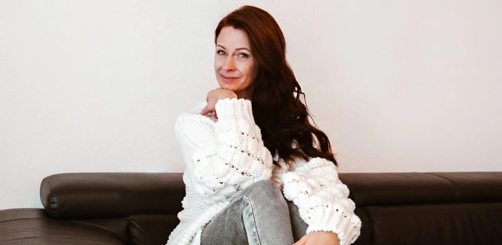 Serene R., the persona for this case study, smiling on a couch